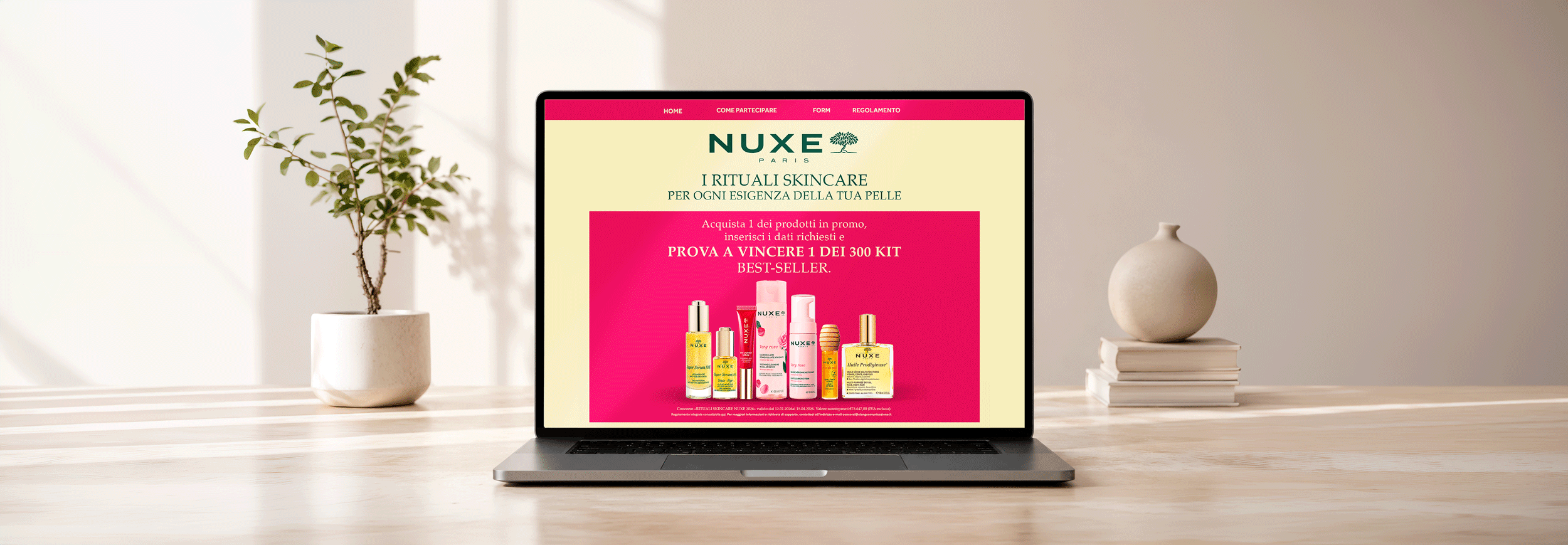 Laptop displaying a NUXE skincare promo page with pink banner and product lineup on a light desk.